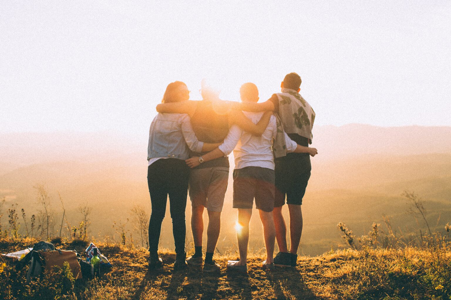 picture of a group of men and women with their arms around each other supporting each other in a health and wellness community